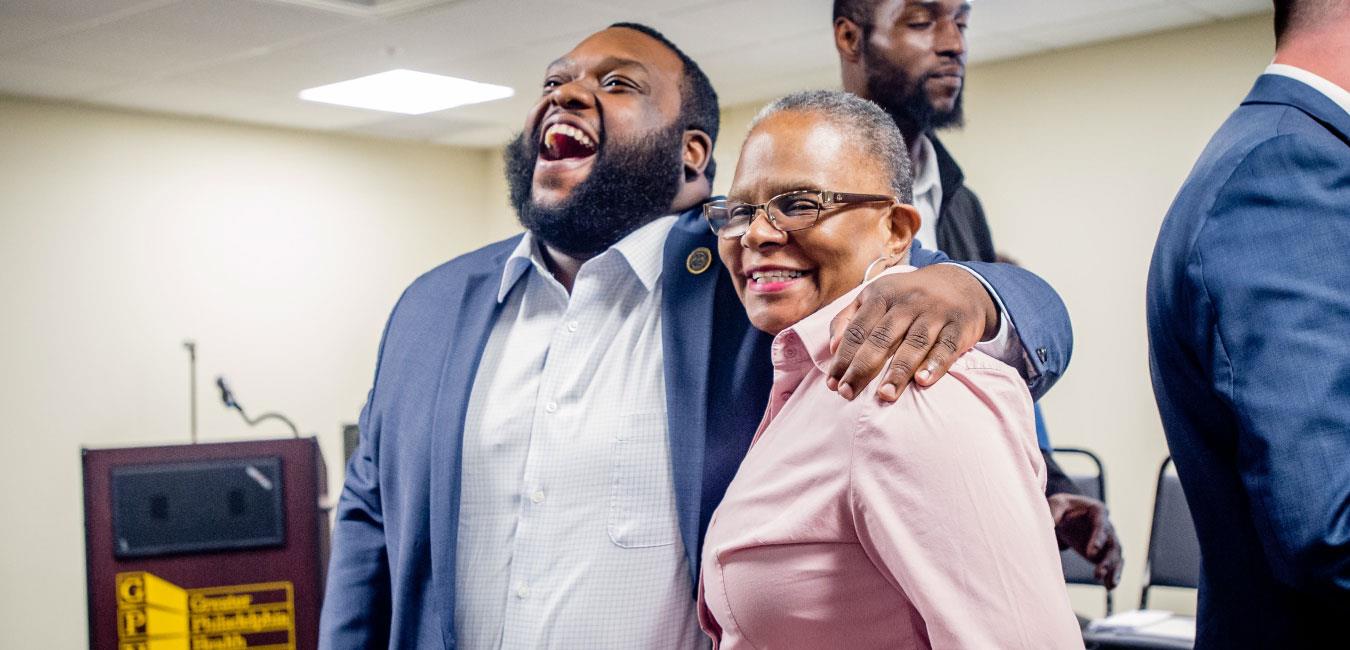 Representative Harris laughing and posing for photo with woman